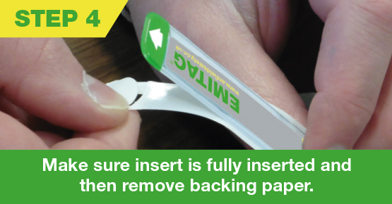 Hand removing backing paper from emitag