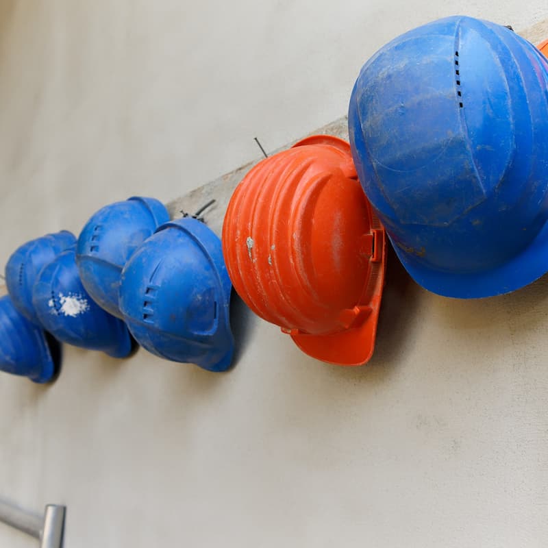 Blue and orange hard hats hanging on wall